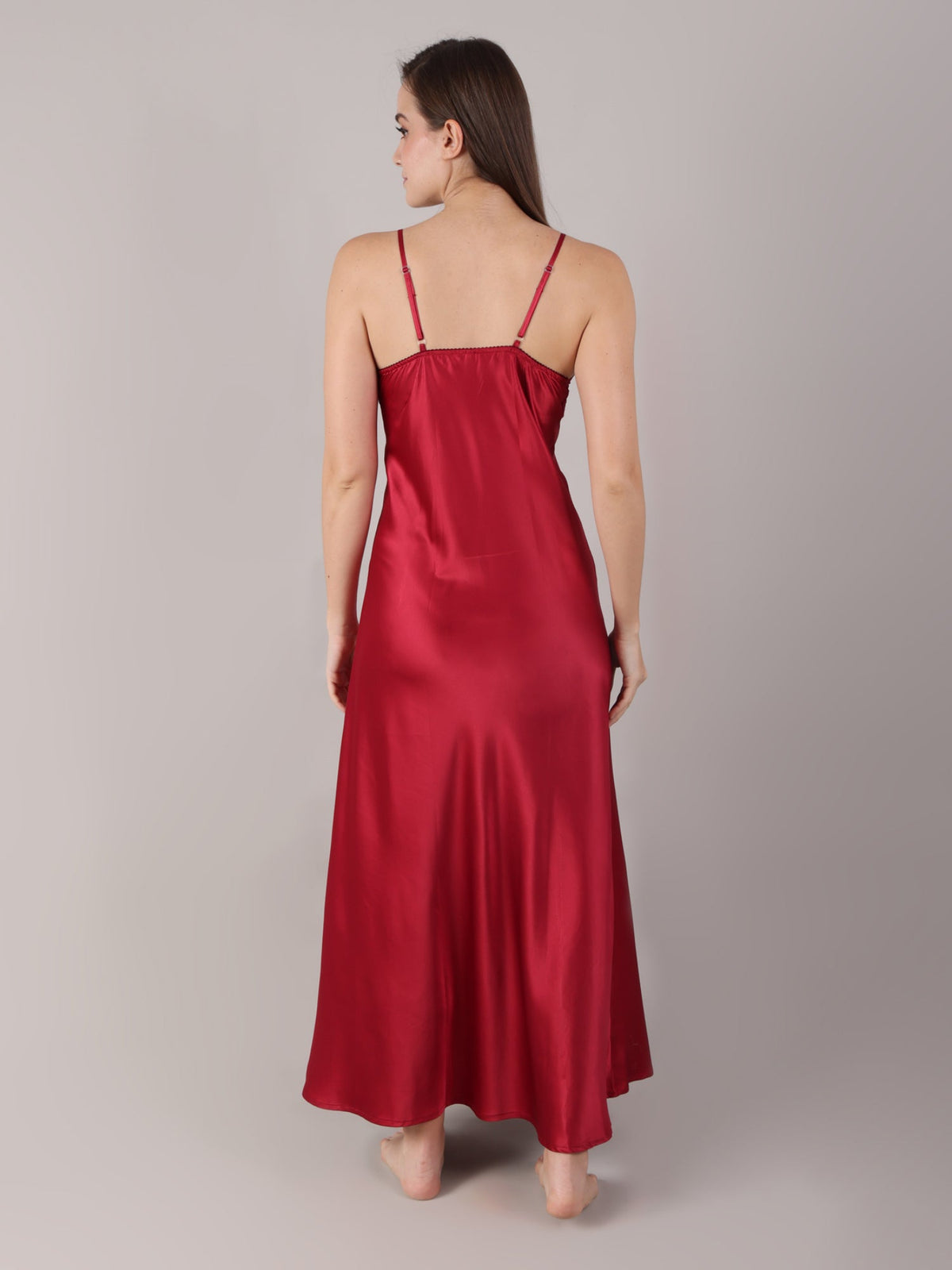 Woman wearing a red satin slip dress against a plain background adjustable straps and elasticated back for a more better body hugging fit