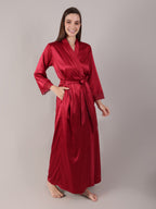 Woman wearing a red satin robe against a plain background